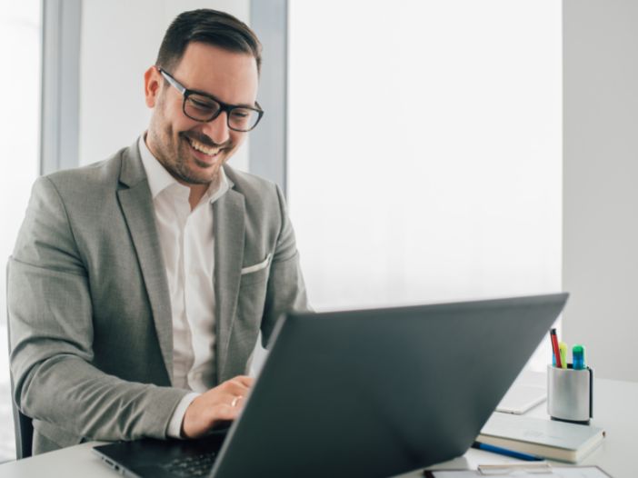 Accountant creating content for his website on laptop