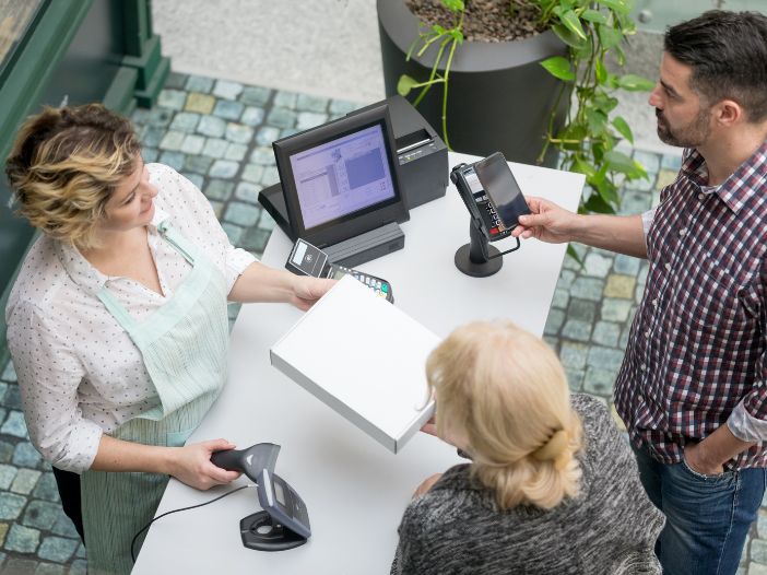 Employee helping customers at checkout counter