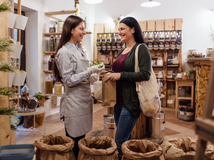 Employee helping smiling customer in shop