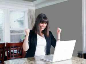 Financial advisor looking at her laptop excited about her new website