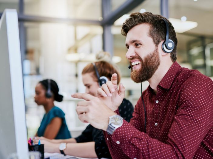 Male Customer Support Rep smiling while helping a customer