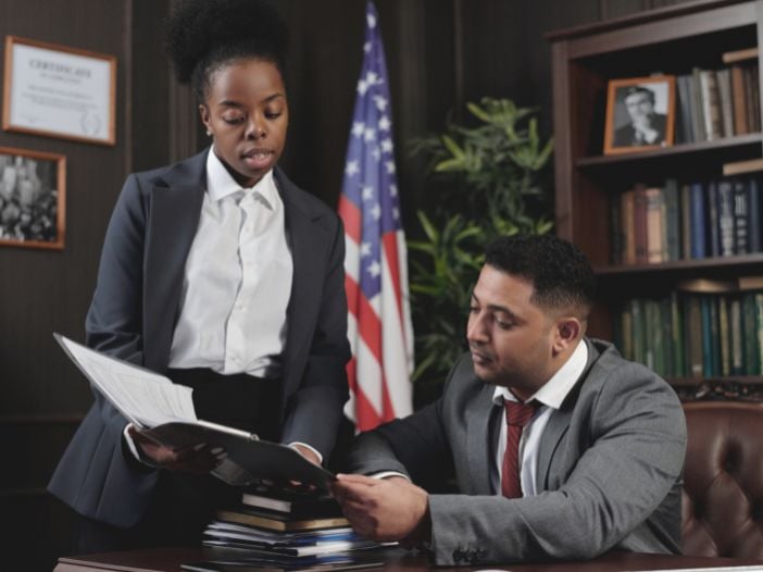 personal injury lawyer and paralegal looking over case notes in office
