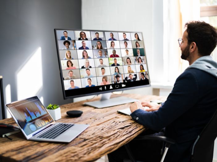 Guy at desk on desktop producing a webinar with many attendees